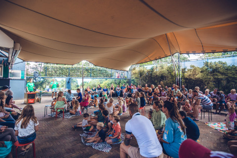 Familias y niños asisten a un evento al aire libre bajo una lona en Holiday Park Ackersate en Gelderland, Países Bajos.