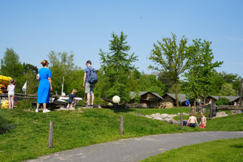 Parque de vacaciones Ackersate en Gelderland, Países Bajos, con familias, niños y tiendas de campaña al sol.