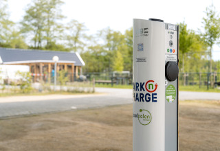Elbil-opladningsstation i Holiday Park Ackersate, Gelderland, Holland, med bygning i baggrunden.