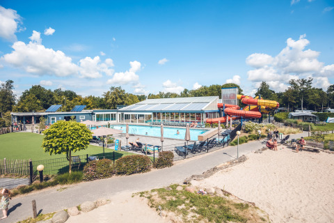 Blick auf den Swimmingpool und die Wasserrutschen im Holiday Park Ackersate, Gelderland, Niederlande bei Sonnenschein.