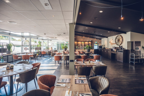 Interior de restaurante moderno y luminoso en Holiday Park Ackersate, Gelderland, Países Bajos, con asientos cómodos.