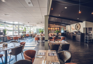 Moderne restaurantindretning med elegante stole og hyggelig belysning på Holiday Park Ackersate i Gelderland.