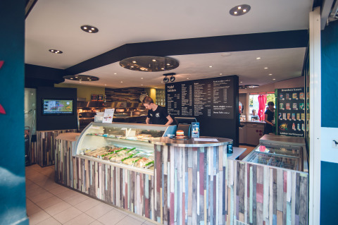 Interior de una cafetería en Holiday Park Ackersate en Gelderland, Países Bajos, con mostrador y menú.