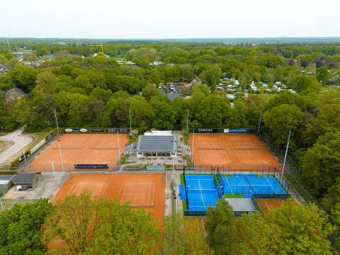 Vista aérea de canchas de tenis y pádel en Holiday Park Ackersate, rodeadas de árboles en Gelderland, Países Bajos.