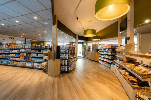 Interior de supermercado luminoso en Holiday Park Ackersate, Gelderland, Países Bajos, con estantes llenos de alimentos.