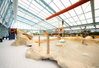 Indendørs vandlegeplads med klatrestruktur og rutsjebane i Holiday Park Ackersate i Gelderland, Holland.
