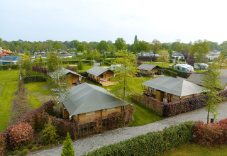 Luchtfoto van Vakantiepark Ackersate in Gelderland, Nederland met lodges, grasvelden en caravans.