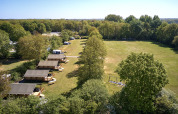 Aerial view of Holiday Resort de Bronzen Emmer in Drenthe, Netherlands, with tents and green fields.