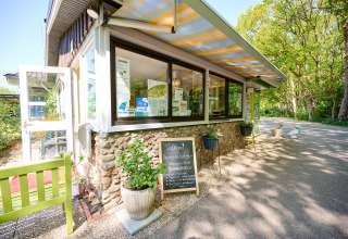 Indgangsparti til feriecentret de Bronzen Emmer i Drenthe, Holland, med grøn natur og udendørs skilt.