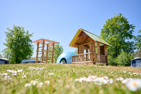 Playground with wooden playhouse and climbing structure at de Bronzen Emmer holiday park in Drenthe, Netherlands.