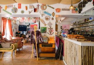 Interior colorido y ecléctico de cafetería o restaurante en Medrose Camping en Auvergne-Rhône-Alpes, Francia.
