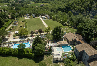 Vista aérea de Medrose Camping, un parque vacacional en Auvergne-Rhône-Alpes, Francia, con piscinas y césped.