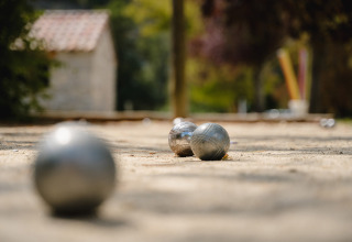 Bocce metalliche per pétanque su ghiaia al Medrose Camping in Auvergne-Rhône-Alpes, Francia, sfondo sfocato.