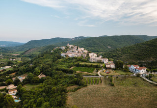 Luchtfoto van Medrose Camping in Auvergne-Rhône-Alpes, Frankrijk, omgeven door groene heuvels en velden.