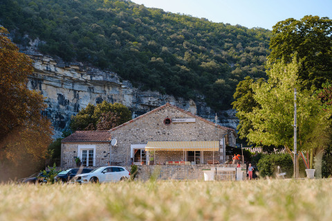 Edificio in pietra al Medrose Camping con montagne e alberi in Auvergne-Rhône-Alpes, Francia, giornata di sole