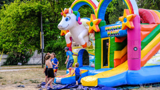 Niños juegan en un colorido castillo hinchable de unicornio en Medrose Camping, Auvernia-Ródano-Alpes, Francia.