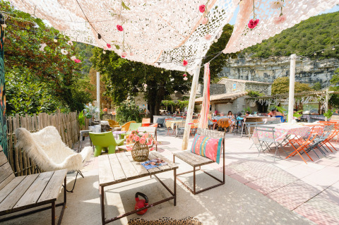 Udendørs loungeområde på Medrose Camping i Auvergne-Rhône-Alpes med farverige stole og blomsterdekoration.