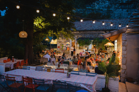 Outdoor dining at Medrose Camping holiday park in Auvergne-Rhône-Alpes, France, with guests at night.