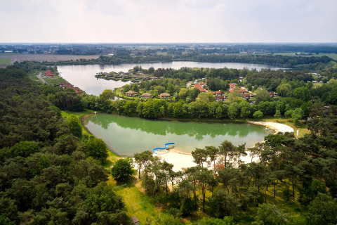 Vista aerea del villaggio vacanze Parc de Witte Vennen con laghi, alberi e cottage in Limburgo, Paesi Bassi.