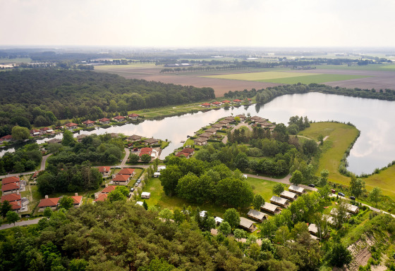 Luchtzicht op Parc de Witte Vennen vakantiedomein met huisjes en een meer in Limburg, Nederland.