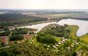 Vista aerea del parco vacanze Parc de Witte Vennen con casette e lago a Limburg, Paesi Bassi.