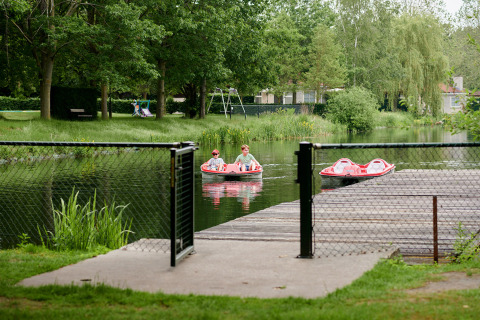 Dos personas en un bote a pedales disfrutan de un estanque en Parc de Witte Vennen, Limburg, Países Bajos.
