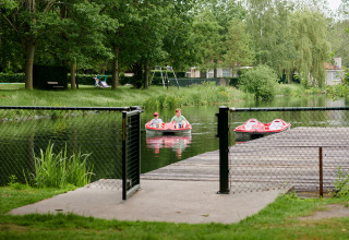 Twee personen op een waterfiets op een vijver in Parc de Witte Vennen, Limburg, omringd door groen.