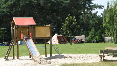 Speeltuin met glijbaan en tentenkamp bij Parc de Witte Vennen vakantiepark, Limburg, Nederland.
