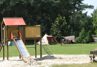 Speeltuin met glijbaan en tentenkamp bij Parc de Witte Vennen vakantiepark, Limburg, Nederland.