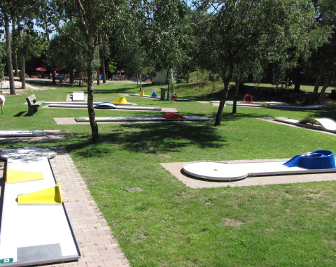 Minigolfbane under træer i det fri i Parc de Witte Vennen, en feriepark i Limburg, Holland.