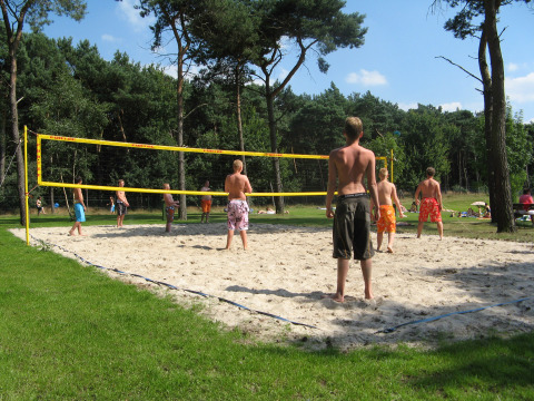 Jóvenes juegan voleibol en una cancha de arena en Parc de Witte Vennen, un parque vacacional en Limburg, Países Bajos.