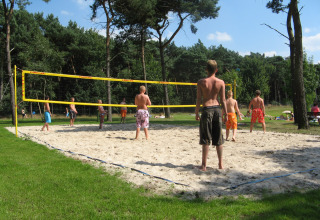 Jóvenes juegan voleibol en una cancha de arena en Parc de Witte Vennen, un parque vacacional en Limburg, Países Bajos.