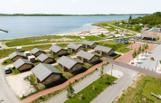 Luftfoto af RCN de Schotsman feriepark i Zeeland, Holland med hytter nær stranden og havet.