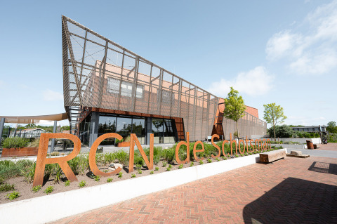 Modern gebouw aan RCN de Schotsman vakantiepark in Zeeland, Nederland, met duidelijk zichtbaar naambord.