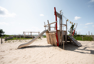 Speelterrein met schip en glijbaan in het zand bij RCN de Schotsman vakantiepark, Zeeland, Nederland.