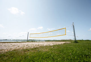 Strandvolleyballbane ved RCN de Schotsman feriested i Zeeland, Holland, med sø og natur i baggrunden.