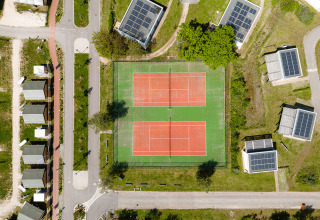 Luchtbeeld van RCN de Schotsman vakantiedomein in Zeeland met tennisvelden en chalets zichtbaar.