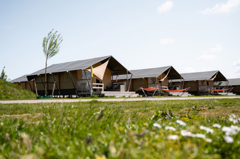 Safaritenten met terrassen en hangmatten bij vakantiepark RCN de Schotsman in Zeeland, Nederland, zonnige dag.