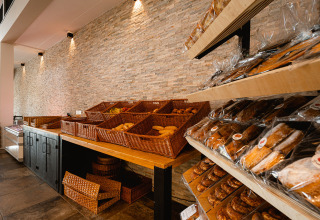 Bakkerijafdeling met manden en rekken vol vers brood bij RCN de Schotsman vakantiepark in Zeeland, Nederland.