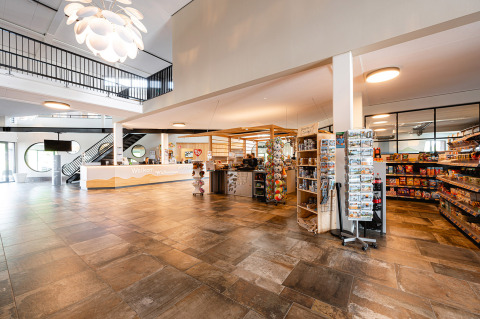 Moderne onthaalruimte en winkel in vakantiepark RCN de Schotsman in Zeeland, Nederland, met snacks en cadeaus.