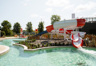 Waterpark met glijbanen en zwembad bij RCN de Schotsman, omringd door bomen in Zeeland, Nederland.