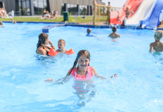 Kinderen amuseren zich en zwemmen in het buitenzwembad van RCN de Schotsman in Zeeland, Nederland.
