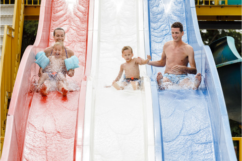 Gezin geniet van glijbanen in RCN de Schotsman vakantiepark, Zeeland, Nederland, met vrolijke kinderen en ouders.