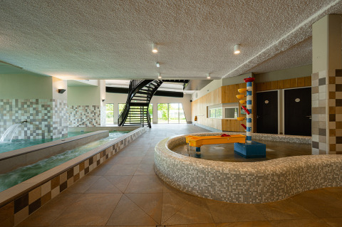 Zona de piscina cubierta con jacuzzi, piscina infantil y escalera de caracol en RCN de Schotsman, Zelanda.