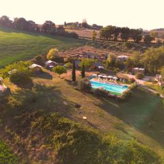 Vue aérienne du parc de vacances Tenuta Tredici Ulivi dans les Marches, Italie, avec piscine et champs.