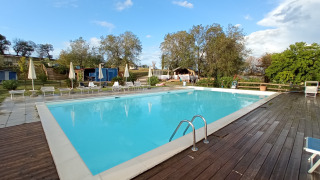 Piscine extérieure avec chaises longues et parasols à Tenuta Tredici Ulivi, parc de vacances dans les Marches, Italie.