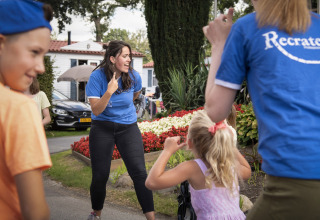Bambini e adulti giocano insieme all'aperto al villaggio turistico Recreatieoord Wilhelm Tell in Limburgo, Belgio.