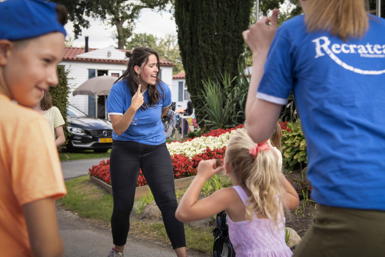 Kinder und Erwachsene spielen gemeinsam draußen im Ferienpark Recreatieoord Wilhelm Tell in Limburg, Belgien.