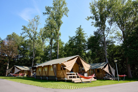 Safari telte med hængekøjer og verandaer i solrigt ferieområde ved Recreatieoord Wilhelm Tell, Limburg, Belgien.