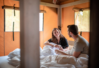 Paar genießt Zeit im Bett mit Kaffee in einer Hütte im Recreatieoord Wilhelm Tell, Belgien.